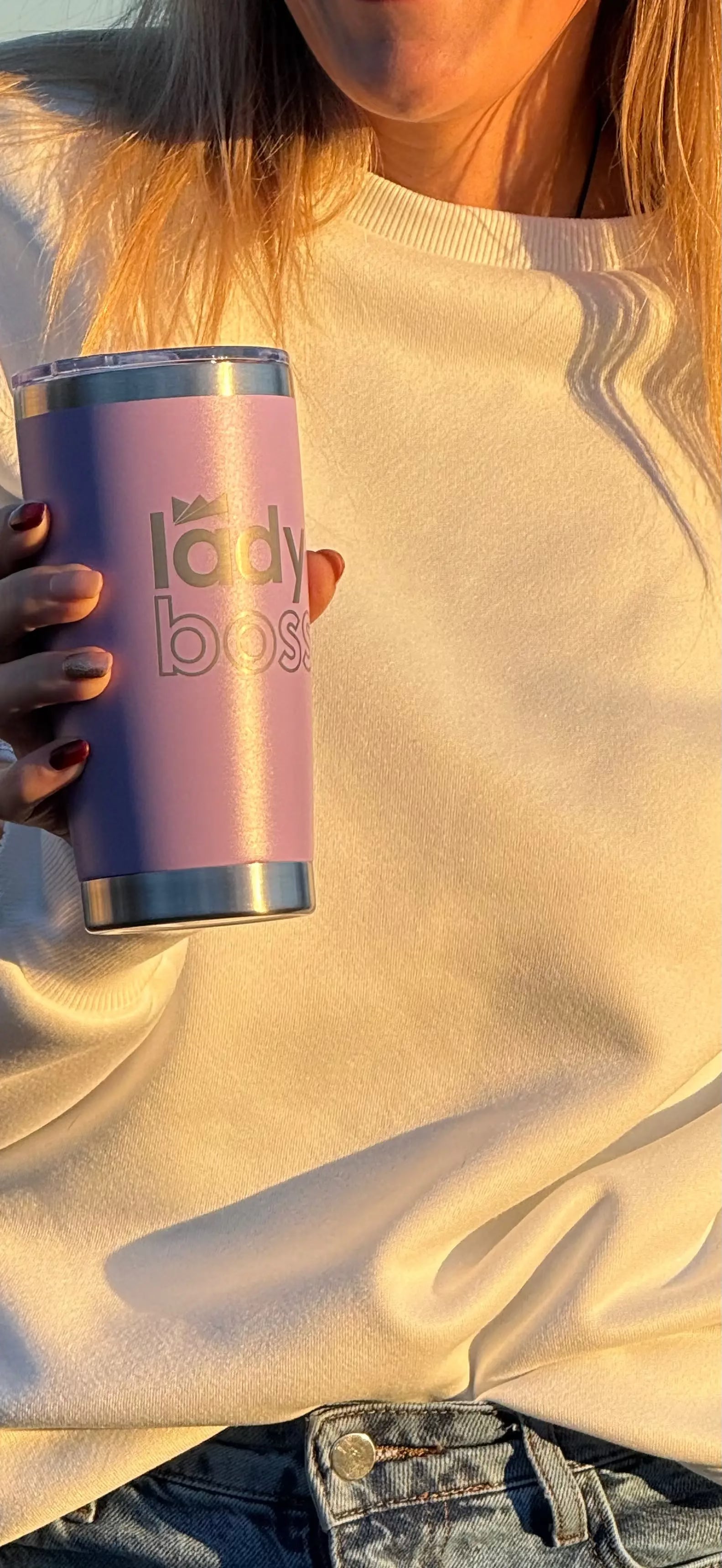 Person holding a pink tumbler with 'lady boss' text.